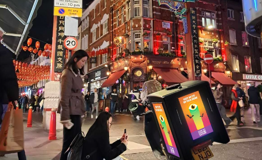 Ad|BOX screen lighting up a busy London street at night, Ad|MOTO UK